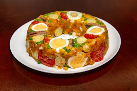 Prato de cuscuz com sardinha decorado com ovos e tomate