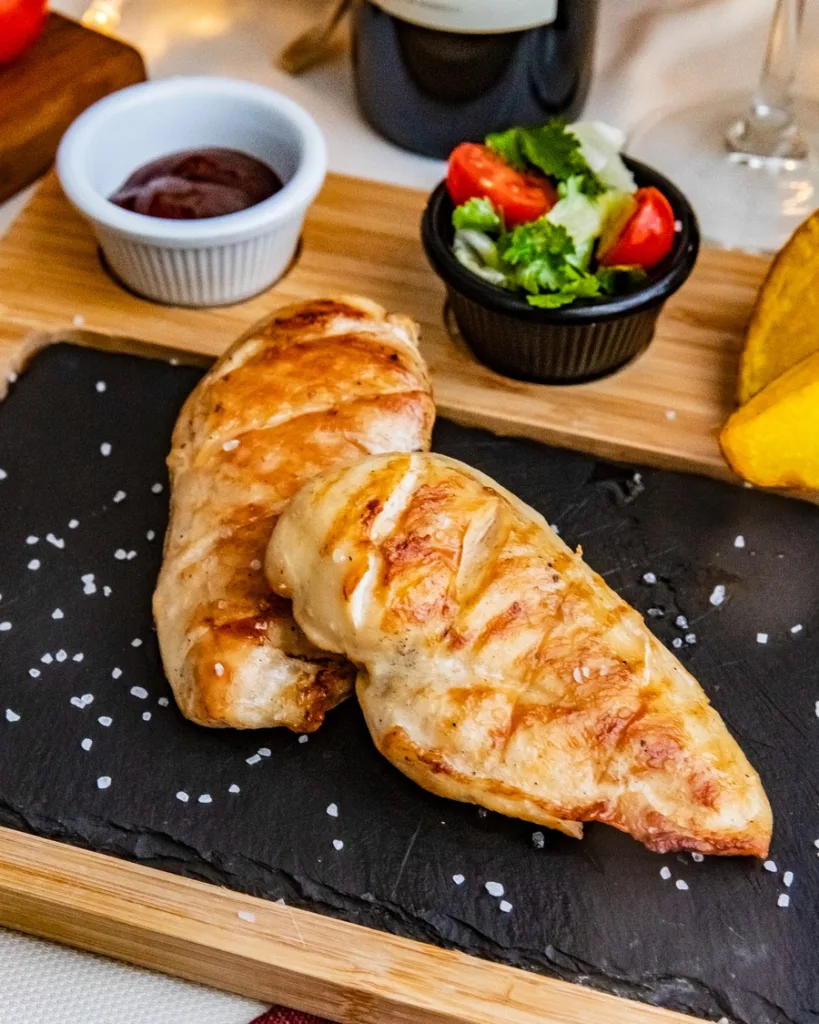 Prato com filé de frango grelhado, hortelã e tomate cereja.